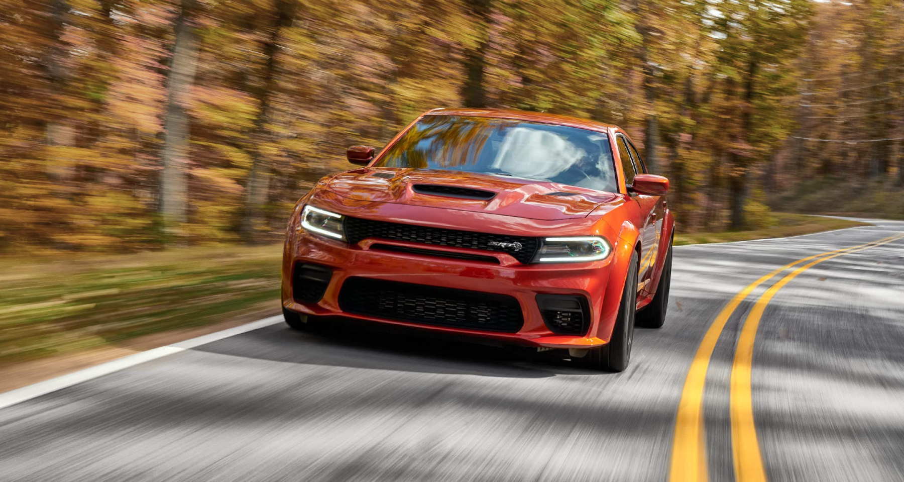 Dodge Charger Drives down road surrounded by forest